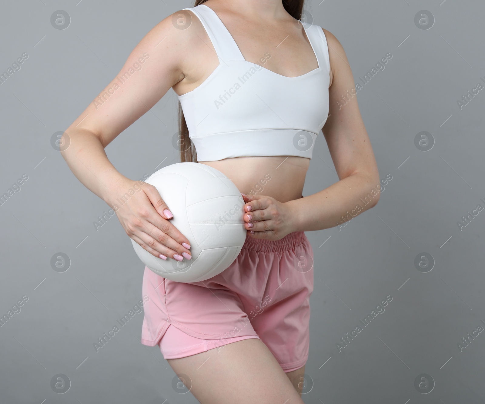 Photo of Woman with volleyball ball on light grey background, closeup