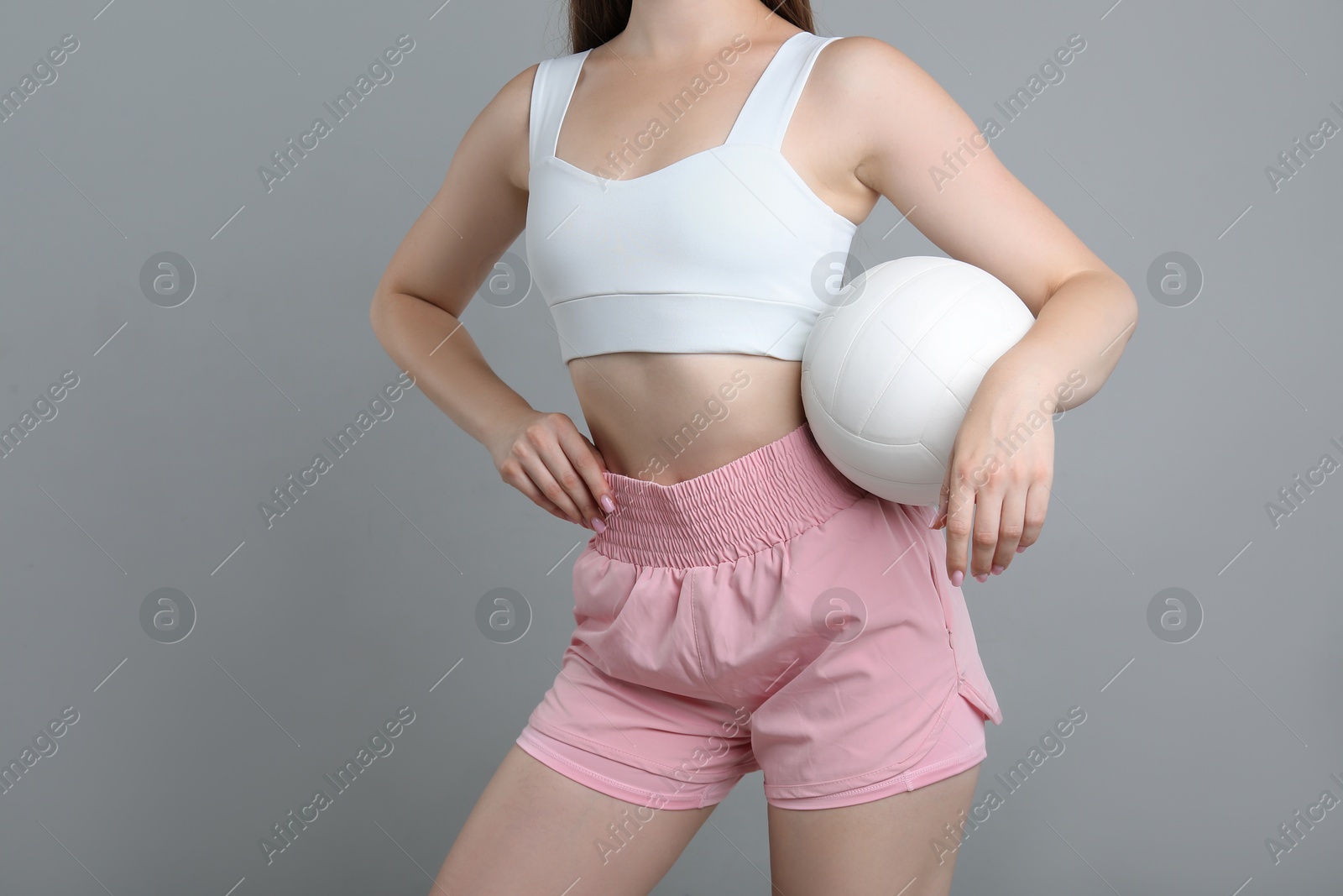Photo of Woman with volleyball ball on light grey background, closeup