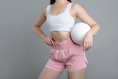 Photo of Woman with volleyball ball on light grey background, closeup