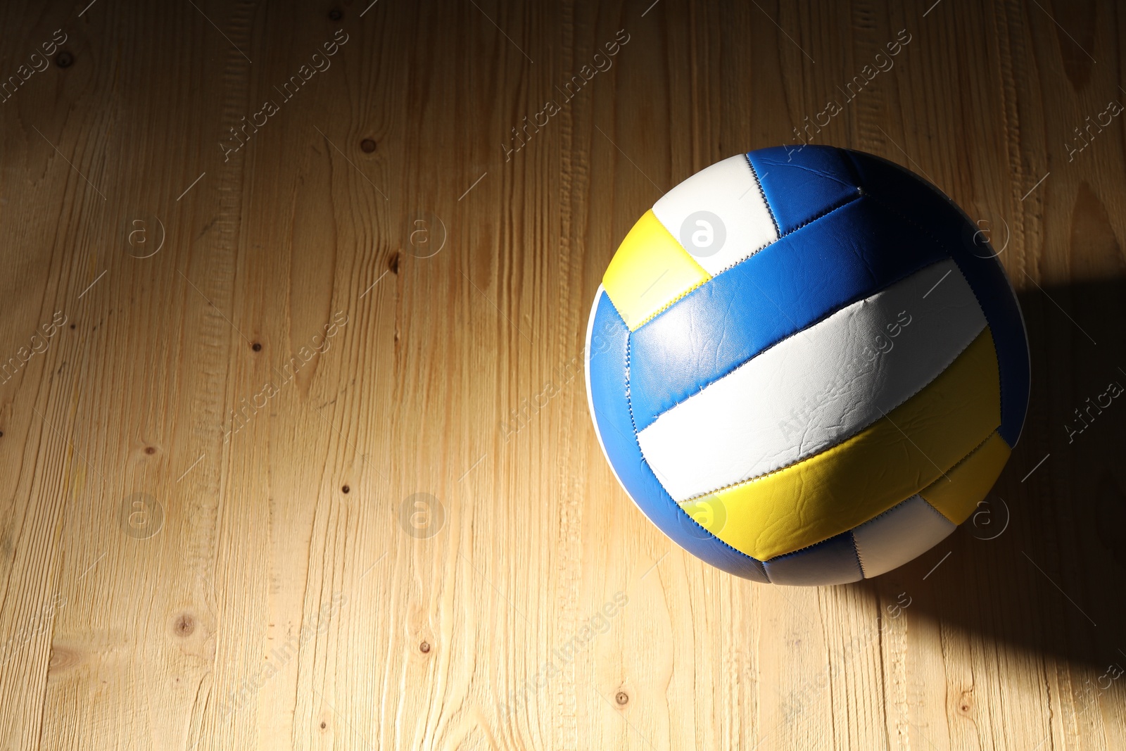 Photo of One volleyball ball on wooden surface, above view. Space for text