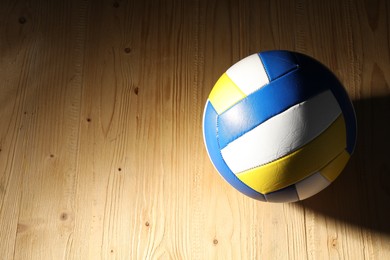 Photo of One volleyball ball on wooden surface, above view. Space for text