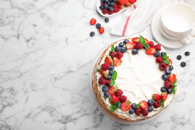 Photo of Delicious crepe cake with fresh berries on white marble table, flat lay. Space for text