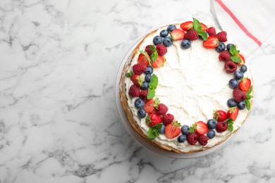 Photo of Delicious crepe cake with fresh berries on white marble table, top view. Space for text