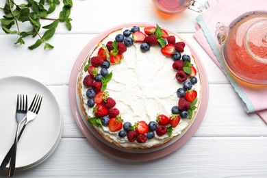 Photo of Delicious crepe cake with fresh berries served on white wooden table, flat lay
