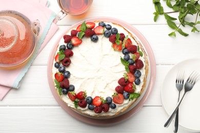 Photo of Delicious crepe cake with fresh berries served on white wooden table, flat lay
