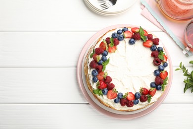Photo of Delicious crepe cake with fresh berries served on white wooden table, flat lay. Space for text