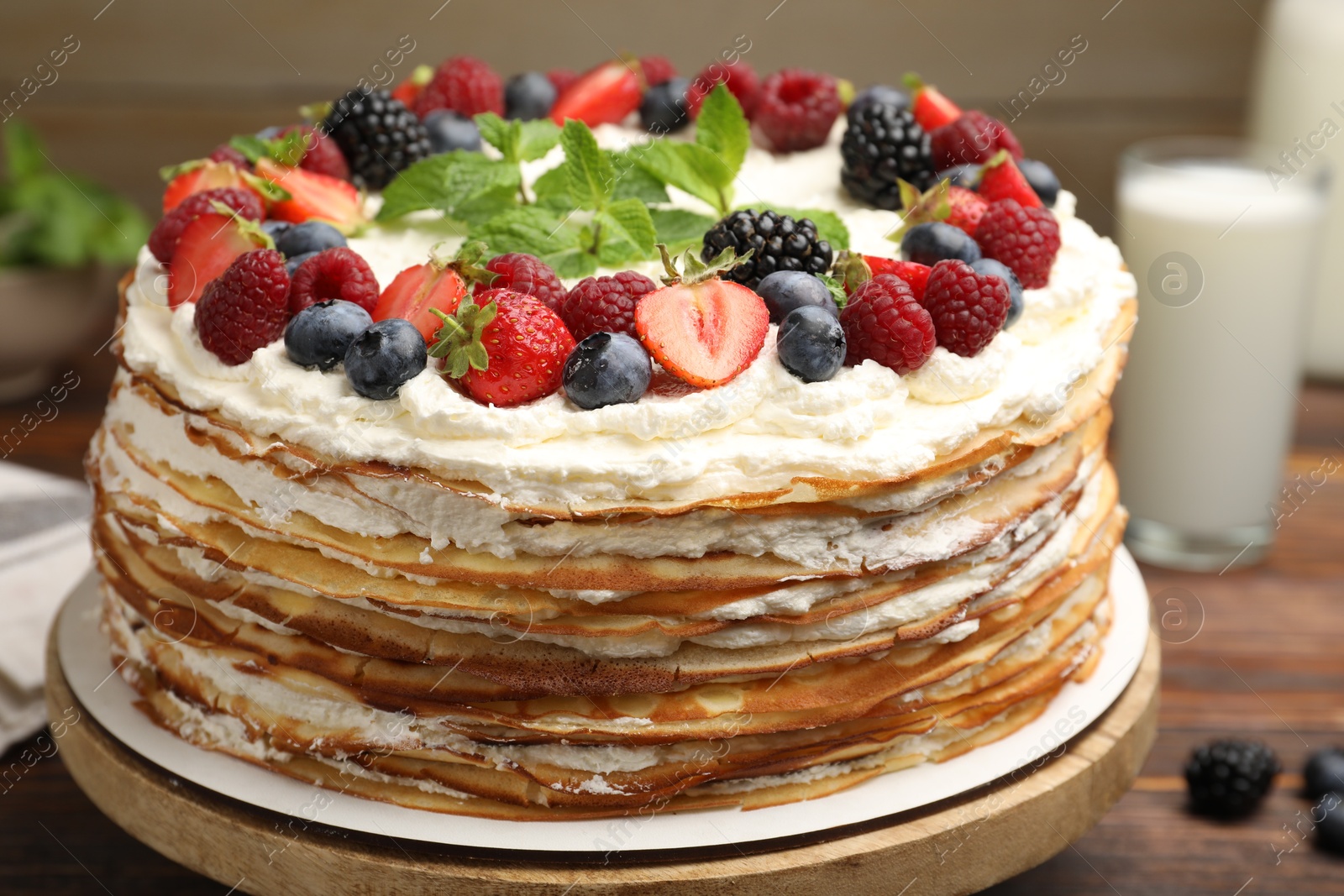Photo of Delicious crepe cake with fresh berries on table, closeup