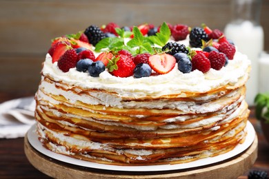 Photo of Delicious crepe cake with fresh berries on table, closeup