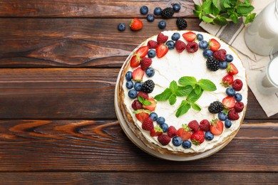 Photo of Delicious crepe cake with fresh berries on wooden table, flat lay. Space for text