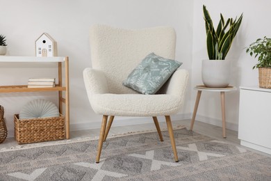 Photo of Stylish armchair, console table and different decor in room. Interior design