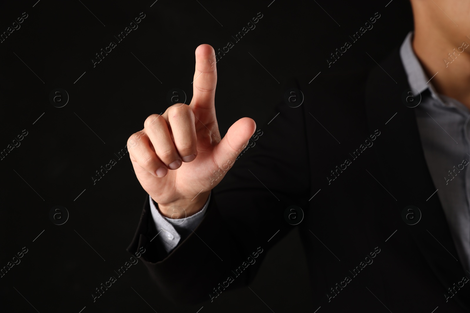 Man touching something on black background, closeup Photo of Man touching something on black background, closeup