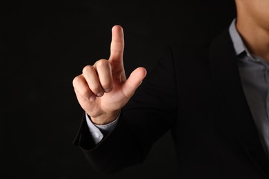 Photo of Man touching something on black background, closeup