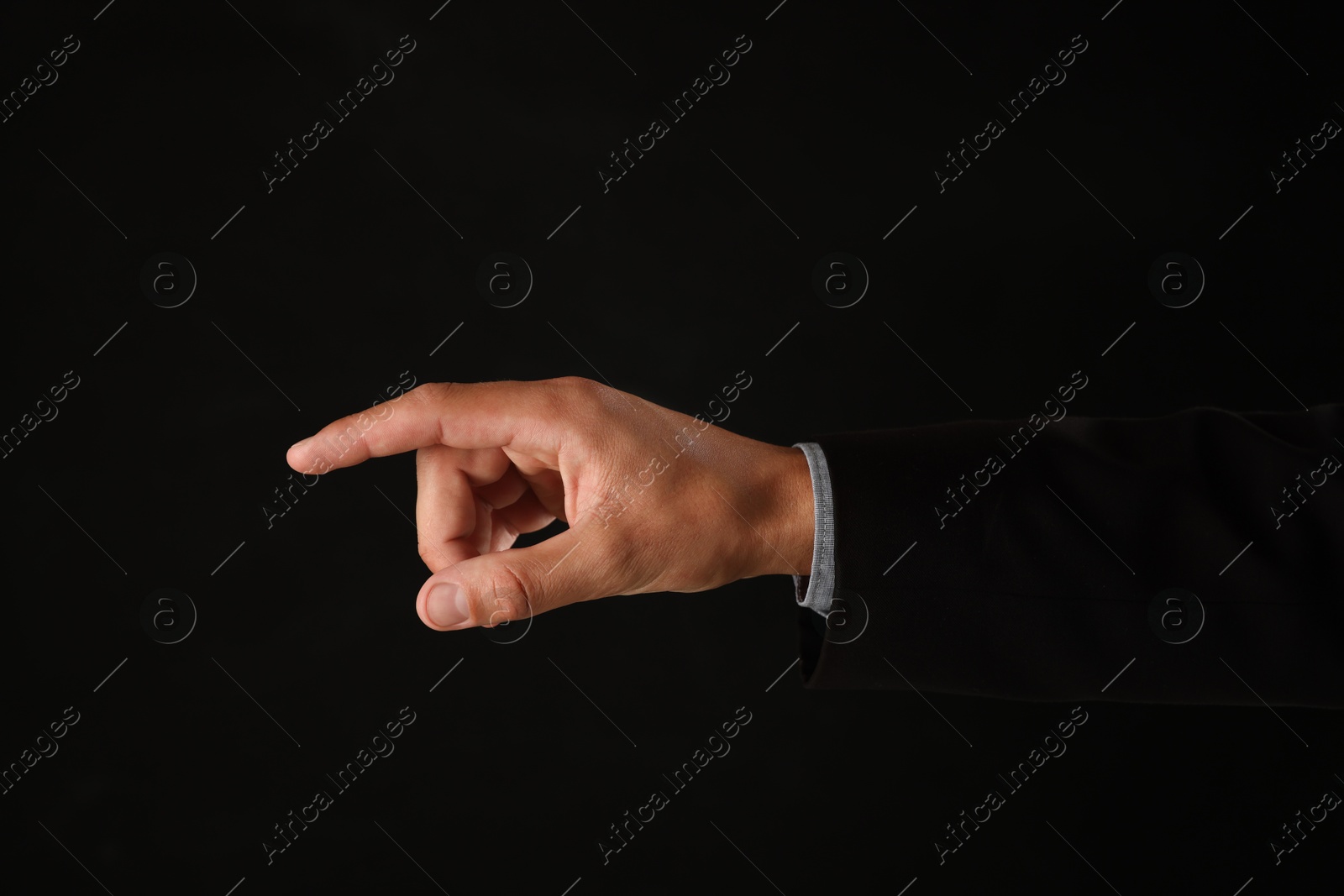 Man touching something on black background, closeup Photo of Man touching something on black background, closeup