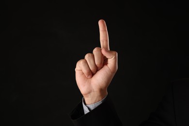 Photo of Man touching something on black background, closeup