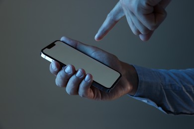 Photo of Man with modern smartphone on grey background, closeup. Mockup for design