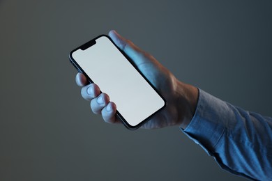 Photo of Man with modern smartphone on grey background, closeup. Mockup for design