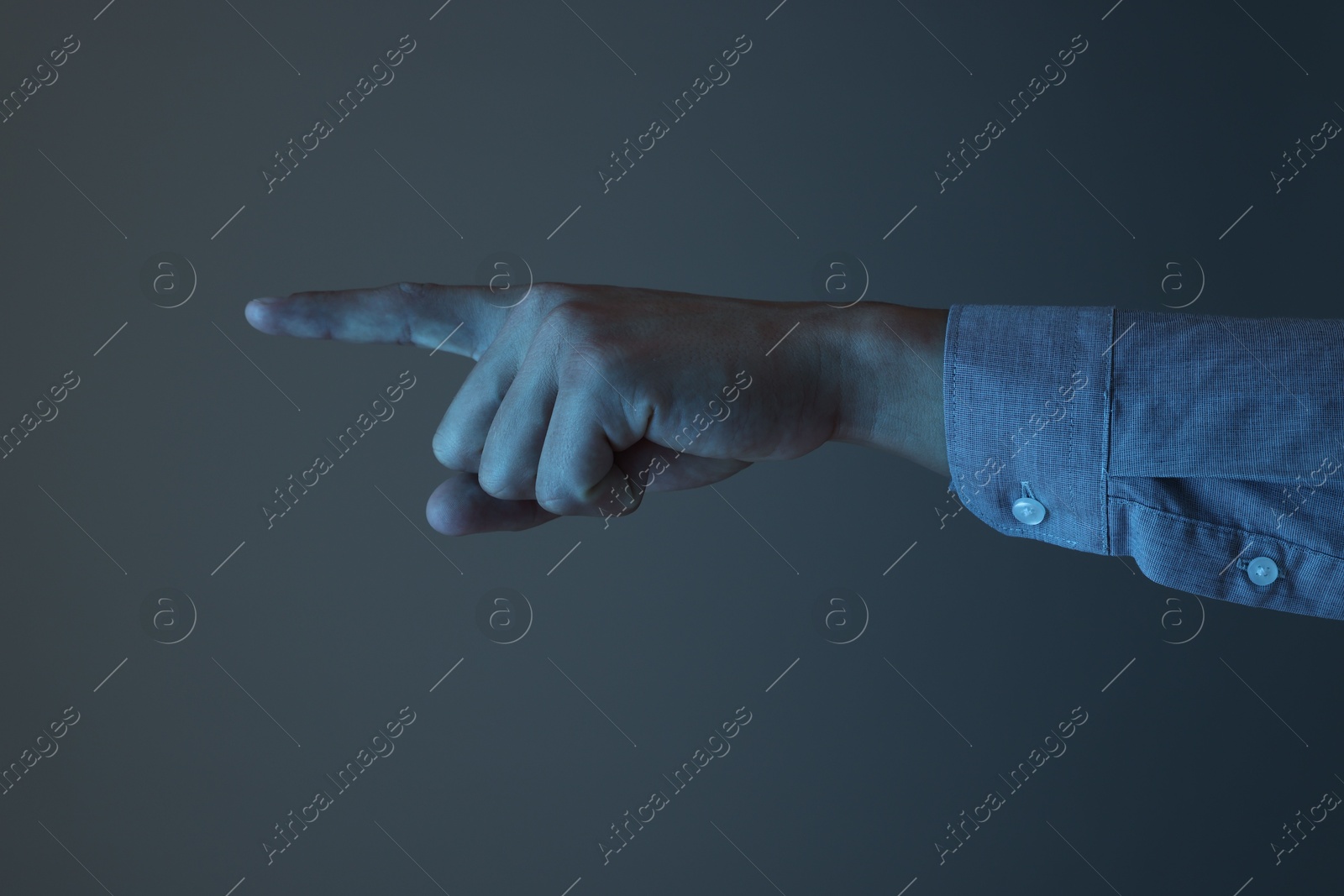 Man touching something on grey background, closeup Photo of Man touching something on grey background, closeup