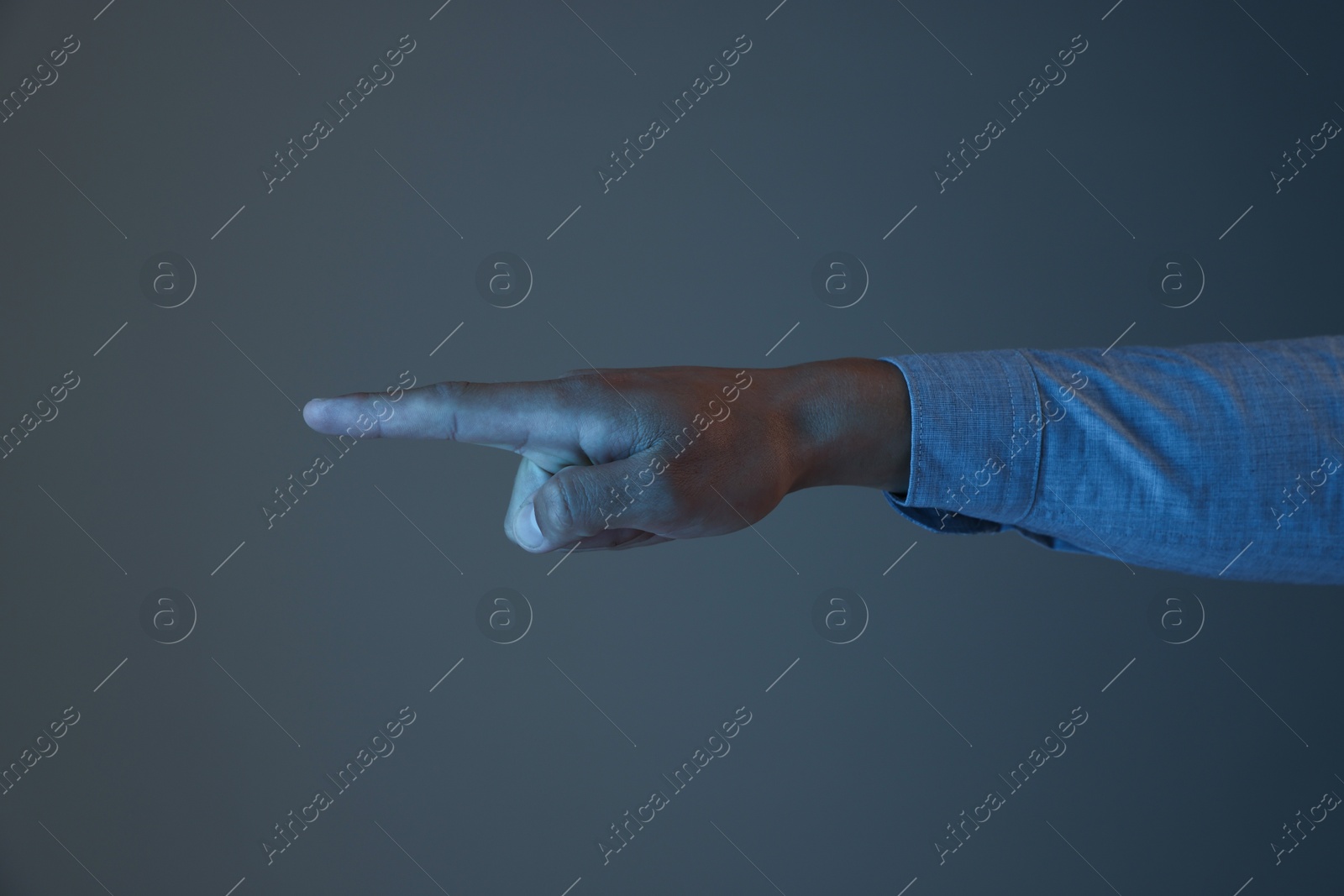 Man touching something on grey background, closeup Photo of Man touching something on grey background, closeup