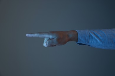 Photo of Man touching something on grey background, closeup