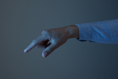 Photo of Man touching something on grey background, closeup