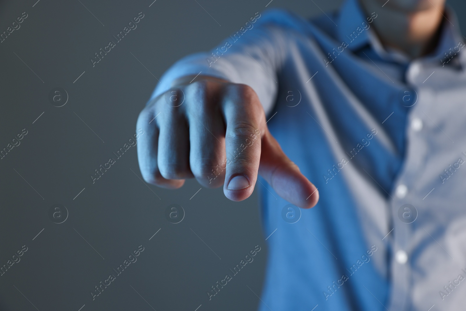 Man touching something on grey background, closeup Photo of Man touching something on grey background, closeup
