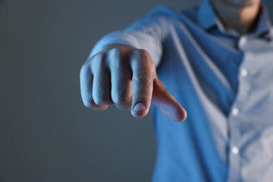 Photo of Man touching something on grey background, closeup