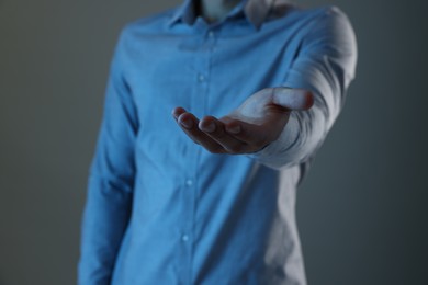 Photo of Man holding something on grey background, closeup