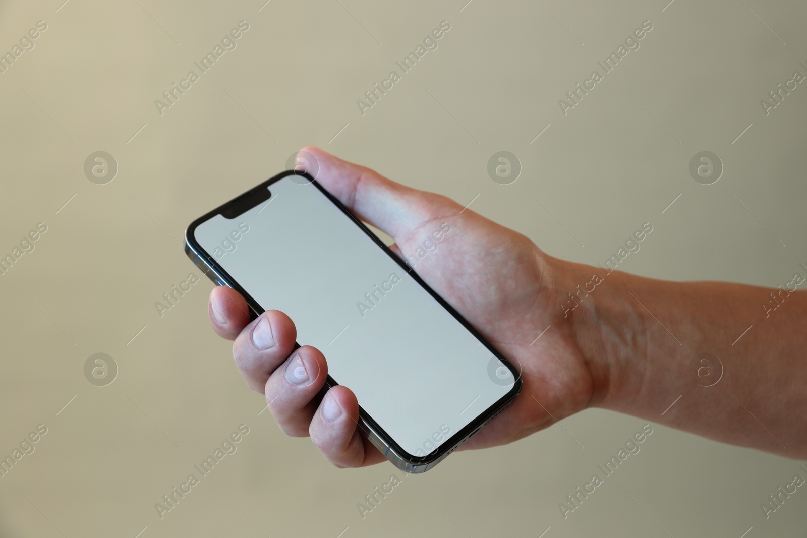 Man with modern smartphone on grey background, closeup. Mockup for design Photo of Man with modern smartphone on grey background, closeup. Mockup for design