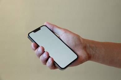 Photo of Man with modern smartphone on grey background, closeup. Mockup for design