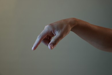 Photo of Man touching something on light grey background, closeup