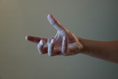 Photo of Man holding something on grey background, closeup