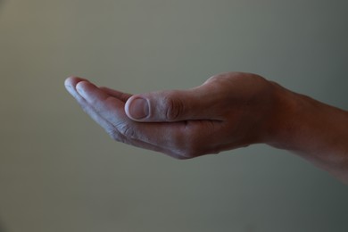 Photo of Man holding something on grey background, closeup