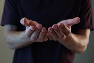 Photo of Man holding something on grey background, closeup