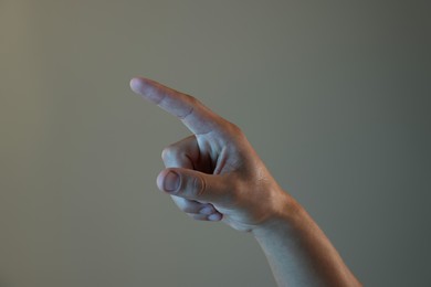 Photo of Man touching something on light grey background, closeup
