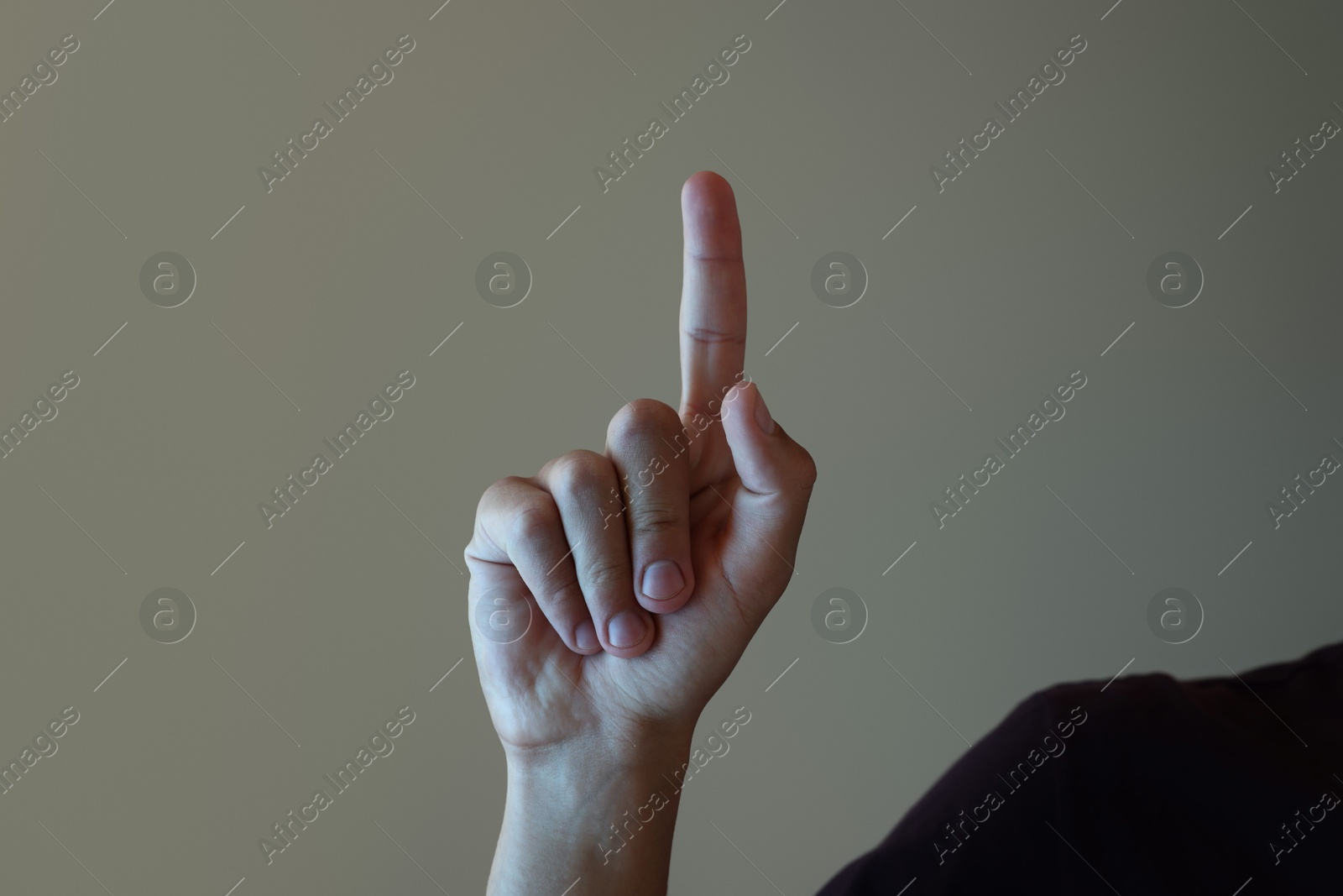 Man touching something on light grey background, closeup Photo of Man touching something on light grey background, closeup