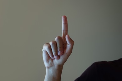 Photo of Man touching something on light grey background, closeup