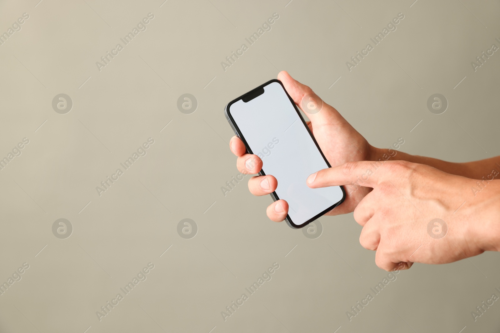 Man with modern smartphone on beige grey background, closeup. Mockup for design Photo of Man with modern smartphone on beige grey background, closeup. Mockup for design