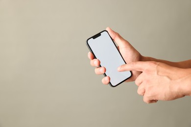 Photo of Man with modern smartphone on beige grey background, closeup. Mockup for design