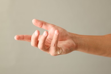 Photo of Man holding something on light grey background, closeup