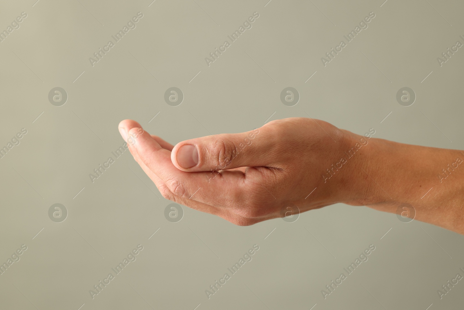 Photo of Man holding something on light grey background, closeup