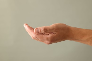 Photo of Man holding something on light grey background, closeup