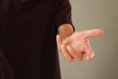 Photo of Man holding something on light grey background, closeup