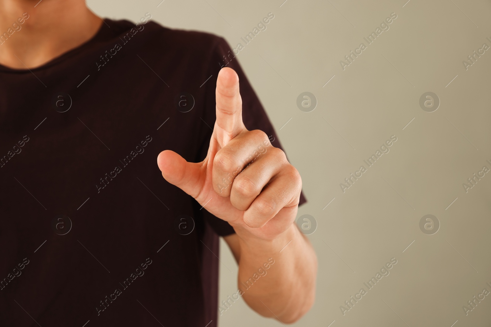 Man touching something on light grey background, closeup. Space for text Photo of Man touching something on light grey background, closeup. Space for text