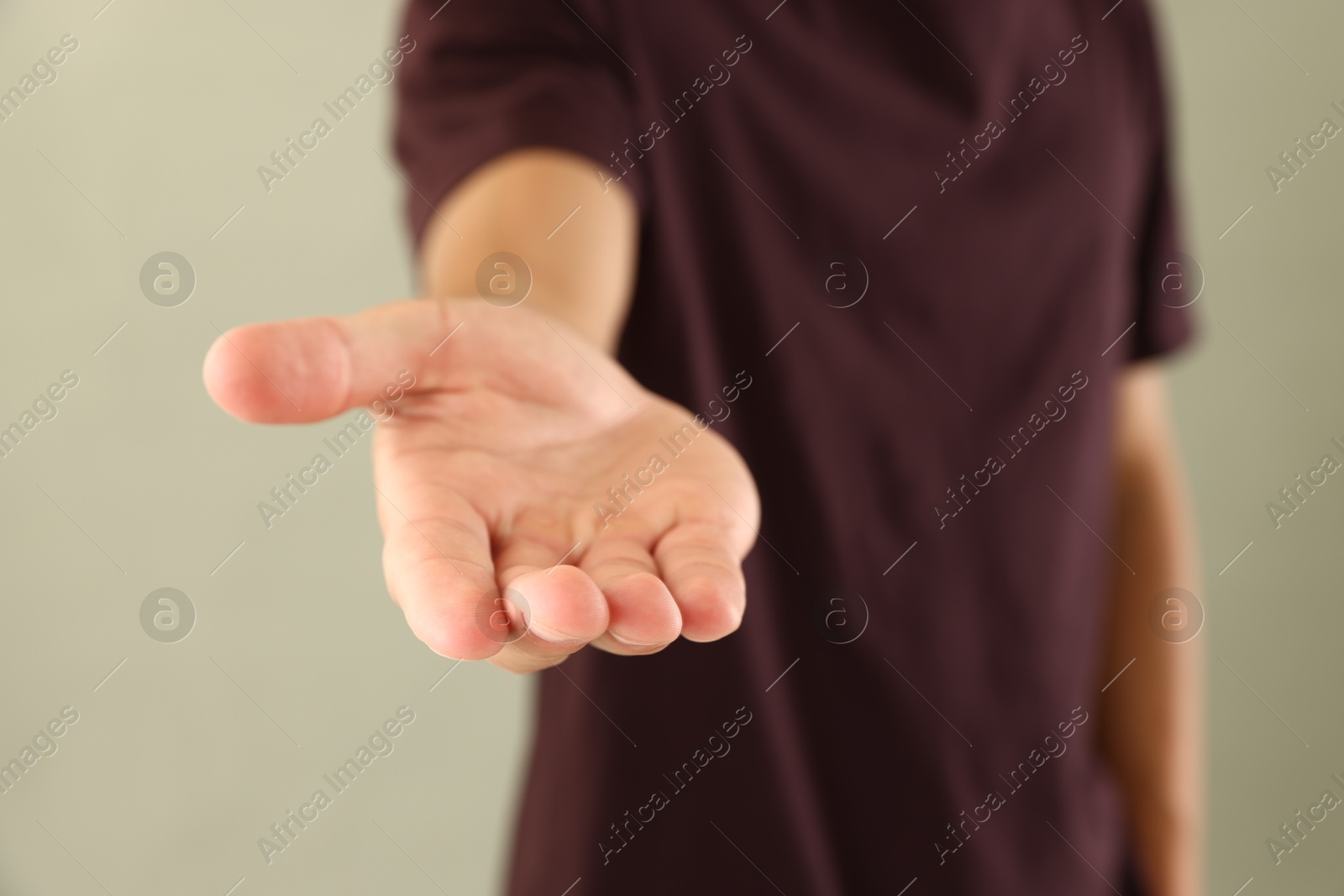 Photo of Man holding something on light grey background, closeup