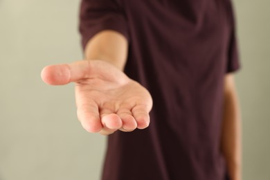 Photo of Man holding something on light grey background, closeup