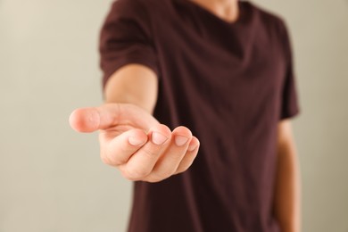 Photo of Man holding something on light grey background, closeup