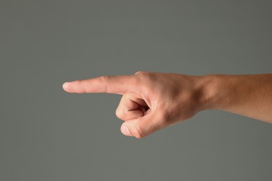 Photo of Man touching something on grey background, closeup