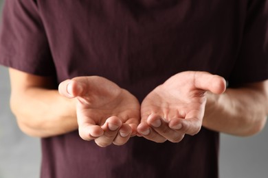 Photo of Man holding something on grey background, closeup