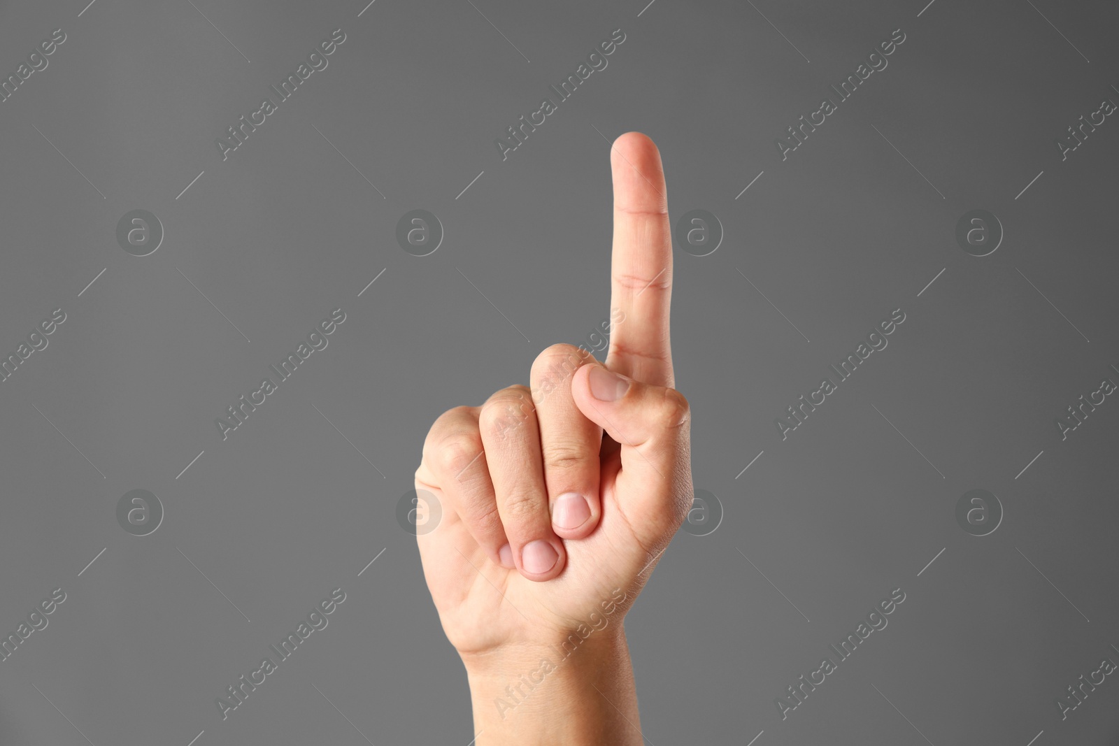 Man touching something on grey background, closeup Photo of Man touching something on grey background, closeup