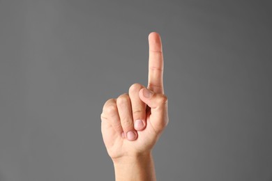 Photo of Man touching something on grey background, closeup